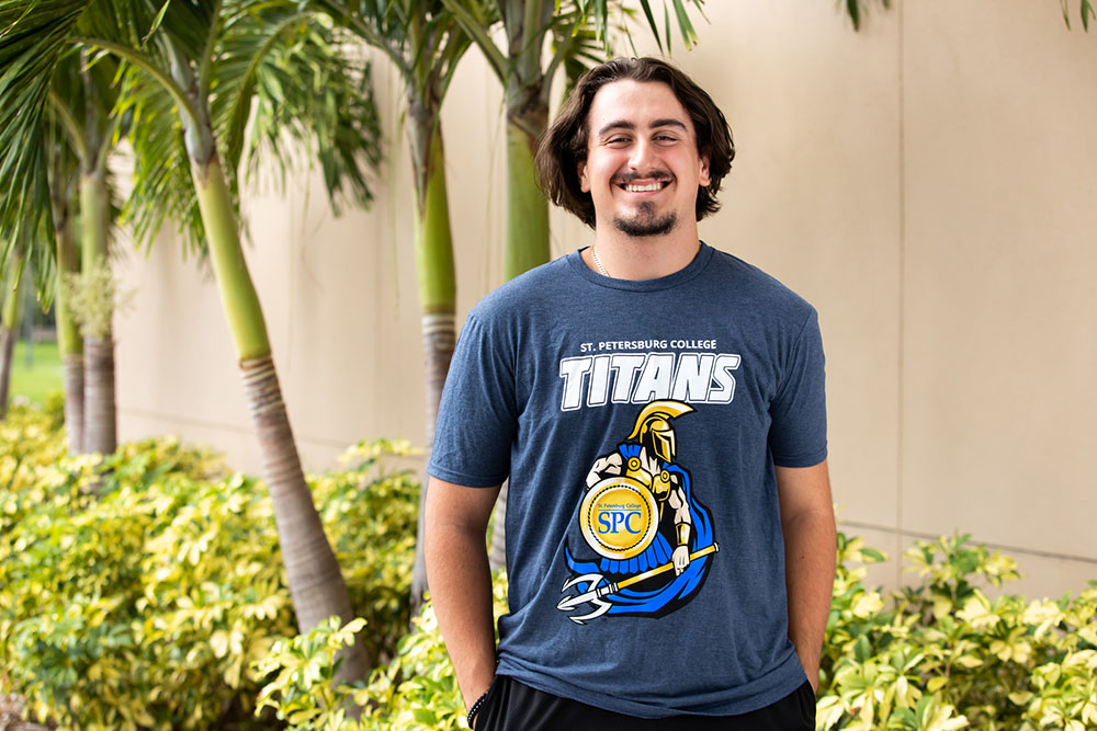 two physical therapy students helping a patient balance on a blue therapy ball