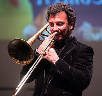 male artist playing a trombone during a concert on the stage at the Palladium at St. Petersburg College