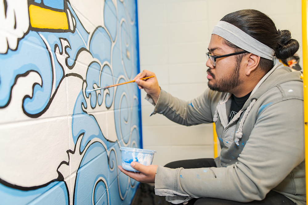 a student painting a mural