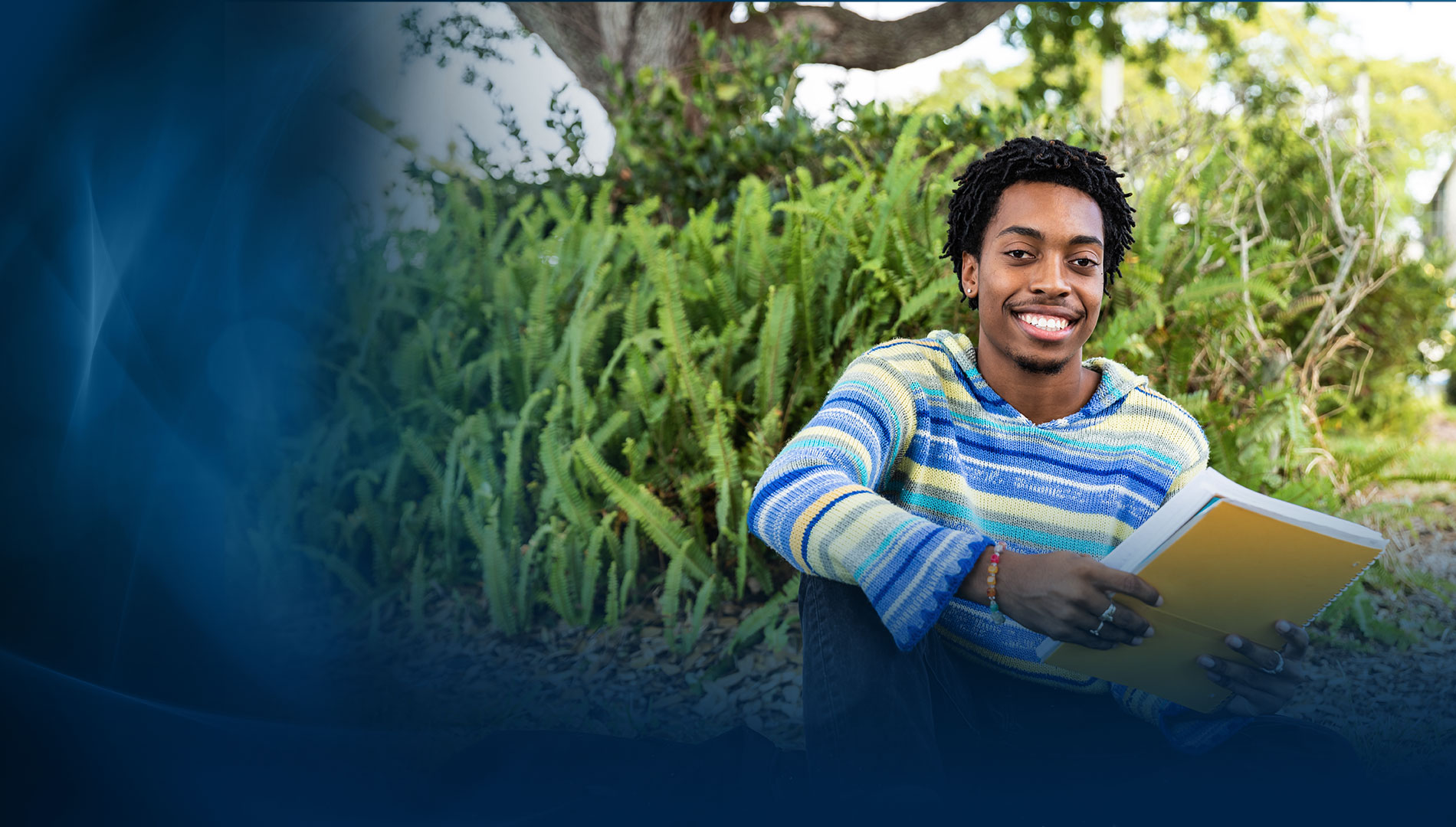 male SPC student holding a notebook outside the Clearwater Campus