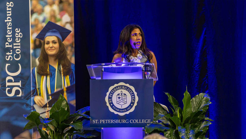 female speaker at podium displaying SPC logo and banner