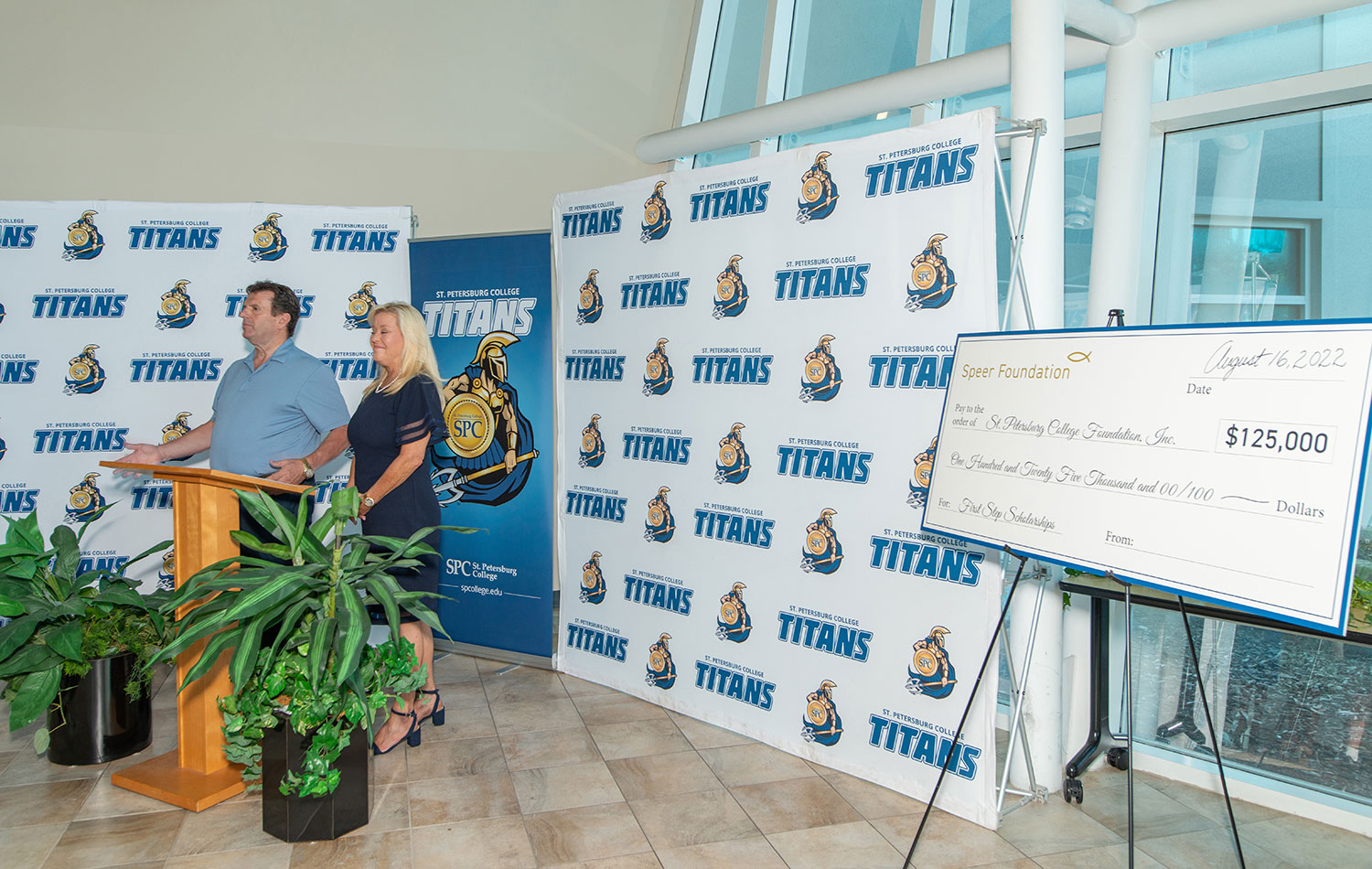 a man and woman on podium presenting award check