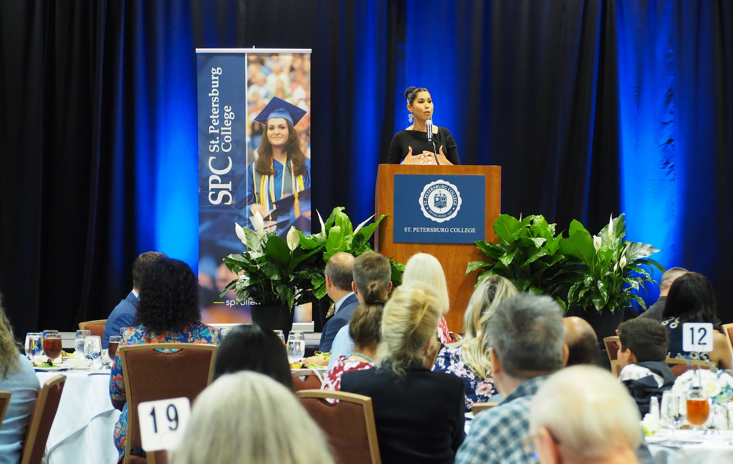 donors and scholars gathered to listen to a speaker at a podium