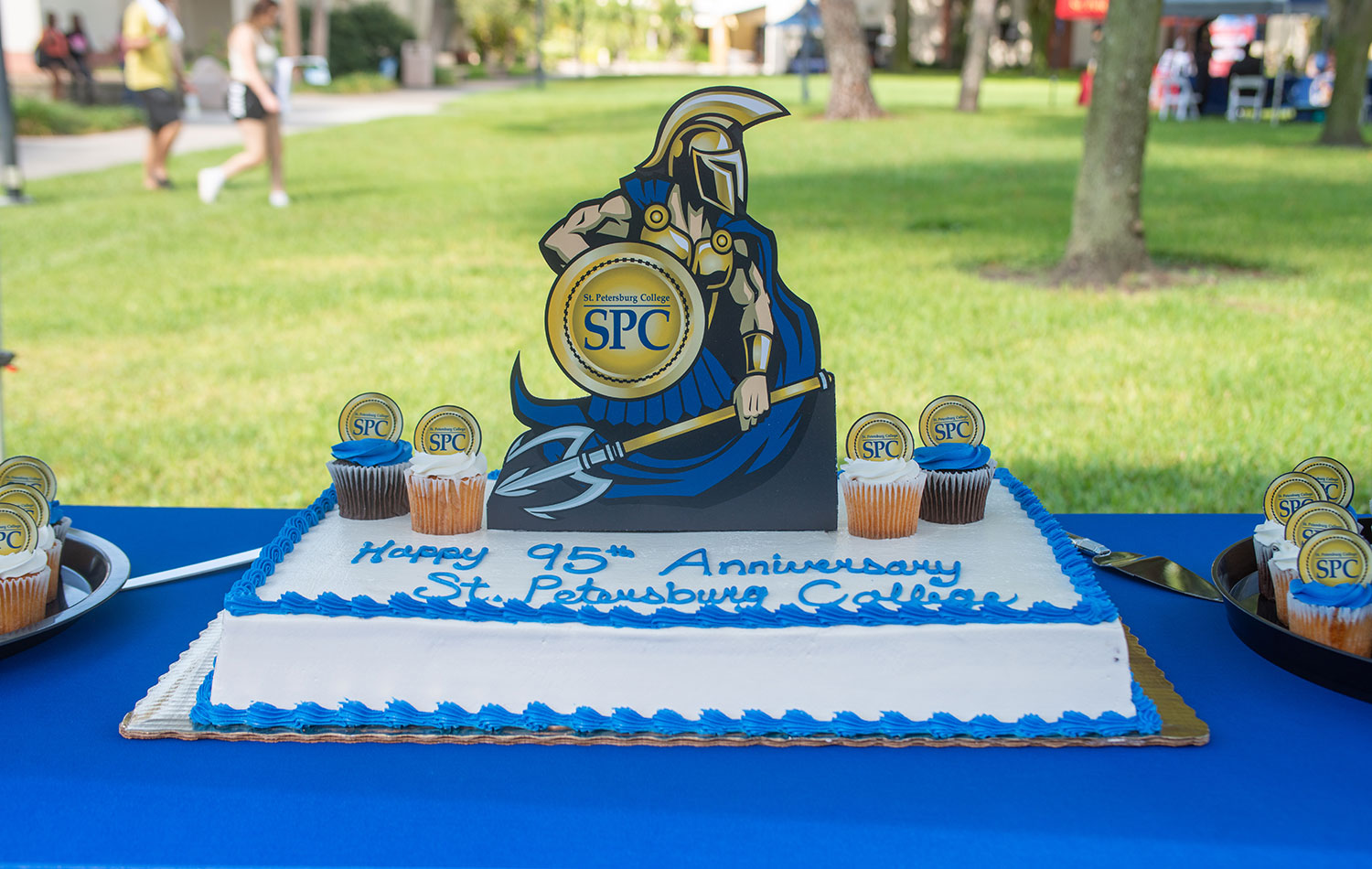 Titus the Titan perched atop the SPC Day cake which reads Happy 95th Anniversary