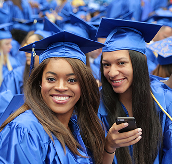 two female SPC Graduate wearing her cap and gown during the graduation ceremony