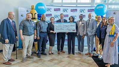 group of people in business attire hilding a giant check