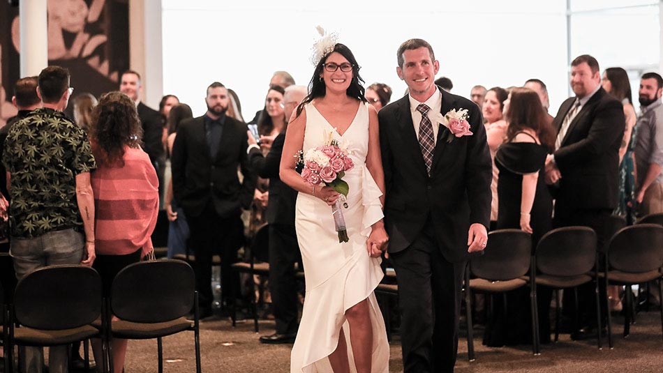 picture of Carissa Roldan in a wedding dress and Jason Nicholson in a suit getting married at the Leppa-Rattner Museum of Art