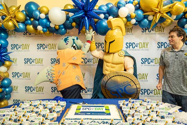 Philey the mascot gives a high five to titus the Titan mascot