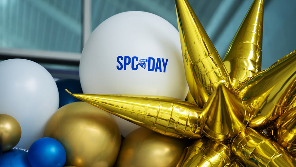 white, blue and gold balloons surrounding a big gold star and a whilte balloon with the words SPC Day