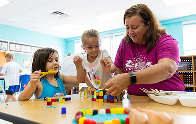 SPC alumna teaching two early child students