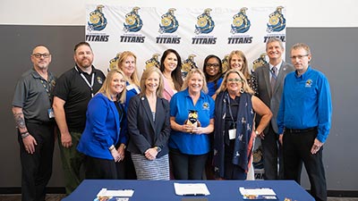 group of SPC and WGU staffers celebrating signing a contract in the table in front of them