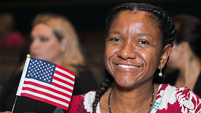 a woman holds an american flag with a big smile on her face