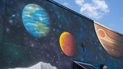 mural of planets in our solar system on the side of a building on the Gibbs Campus