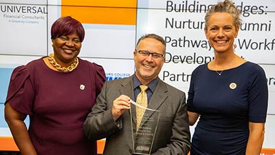 Theresa McFarland, SPC Foundation Executive Director of Annual Giving & Alumni Engagement Program, and Sara Sabourin, SPC Business Relationship Manager, present the Building Bridges: Nurturing Alumni Pathways and Workforce Development Award to Jeff Mowry, Senior Financial Designer for Universal Financial Consultants.