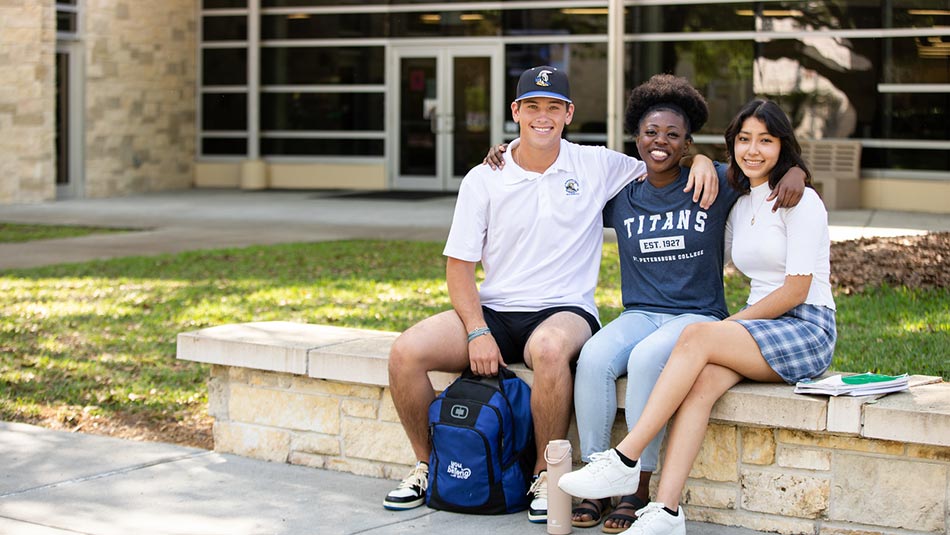 three students in shorts and jeans and tshirts sitting outside the Clearwater Campus