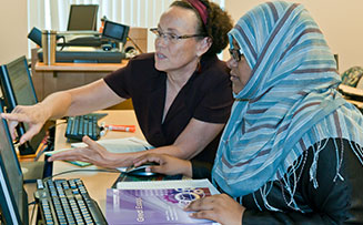 a professor helping a student at her computer