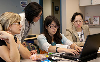 a group of students working together on a computer