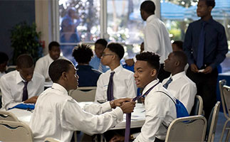 Men Achieving Excellence Student Club gathering. One student helping the other with his neck tie.