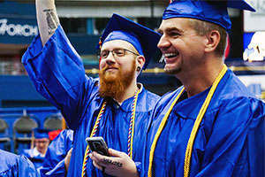 graduates waving