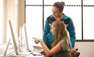 an instructor answering a student's question at her computer