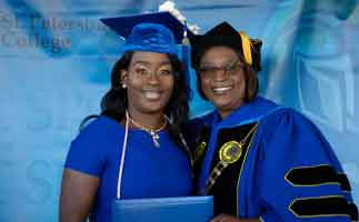 SPC President, Dr. Tonjua Williams standing with a female graduate