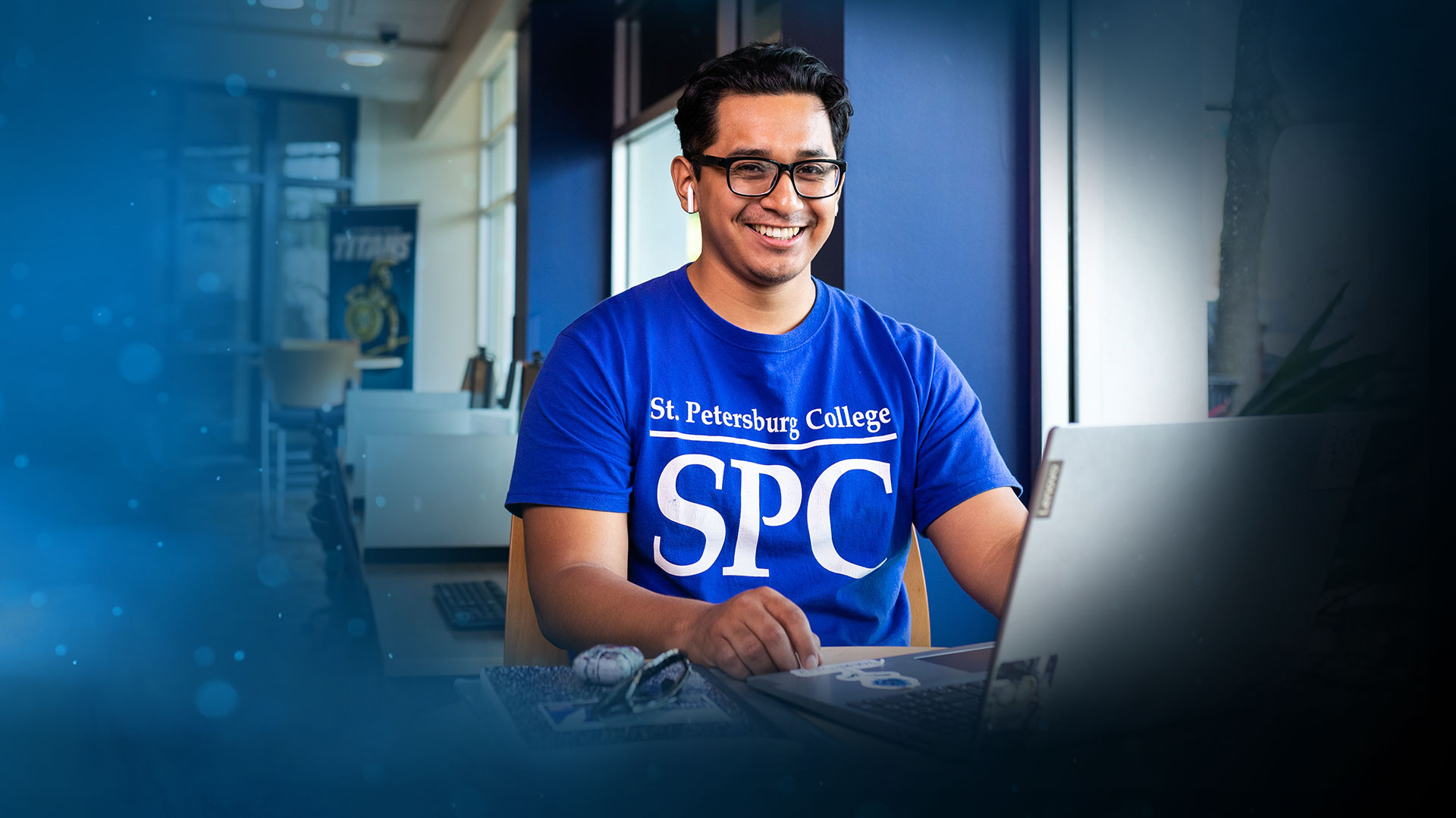 spc student sitting at a laptop computer smiling