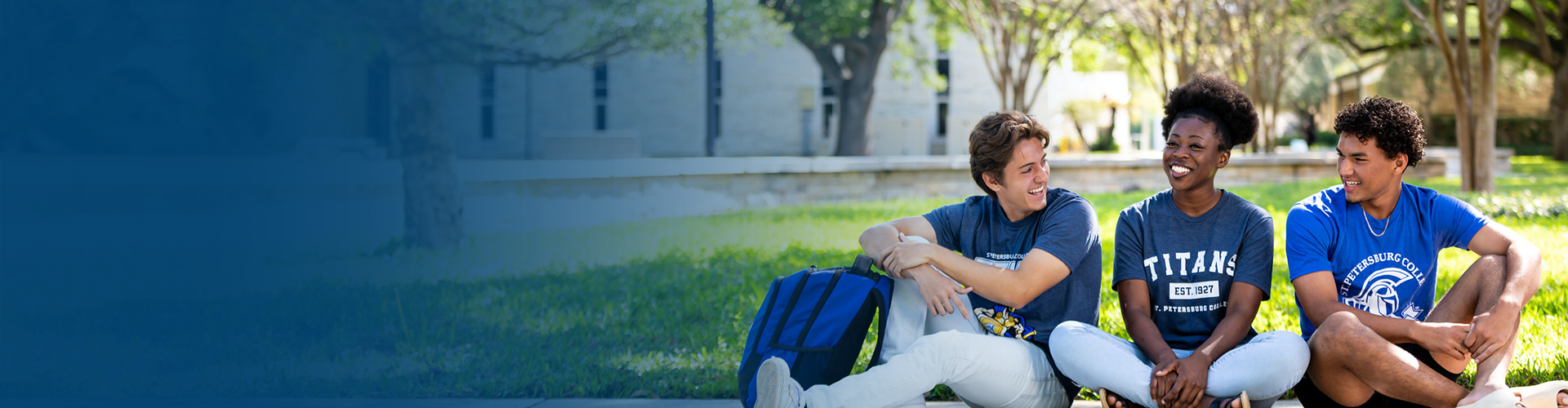 3 SPC students sitton on the lawn smiling