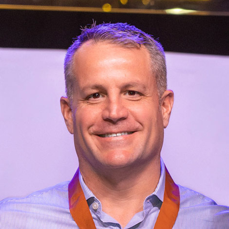 portrait of Nicholas Manias wearing a lanyard and blue button down shirt