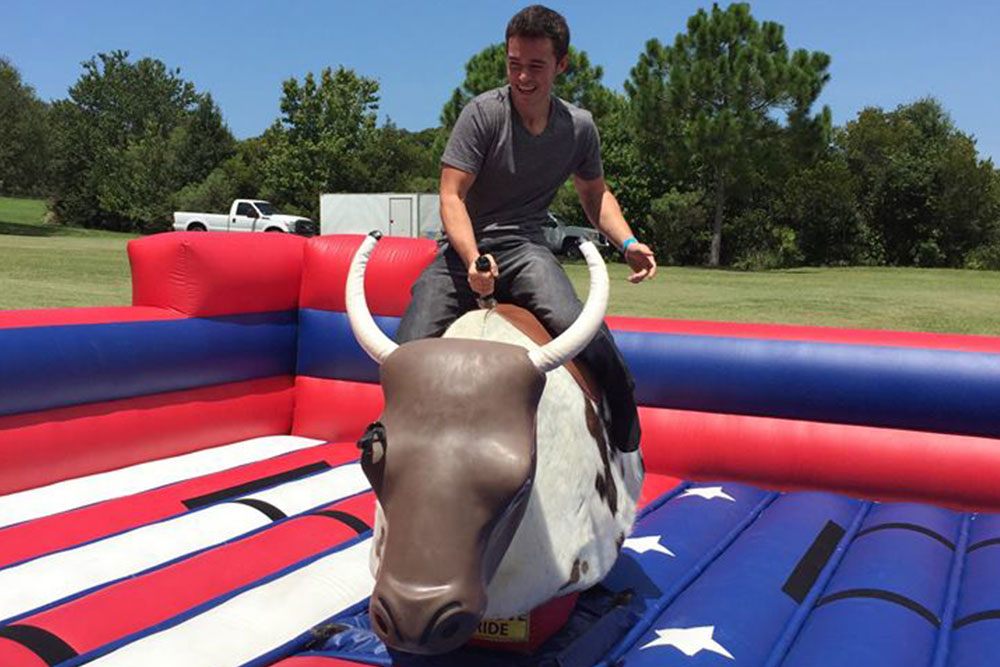 A student riding a mechanical bull at the SPC Seminole Campus Welcome Back event