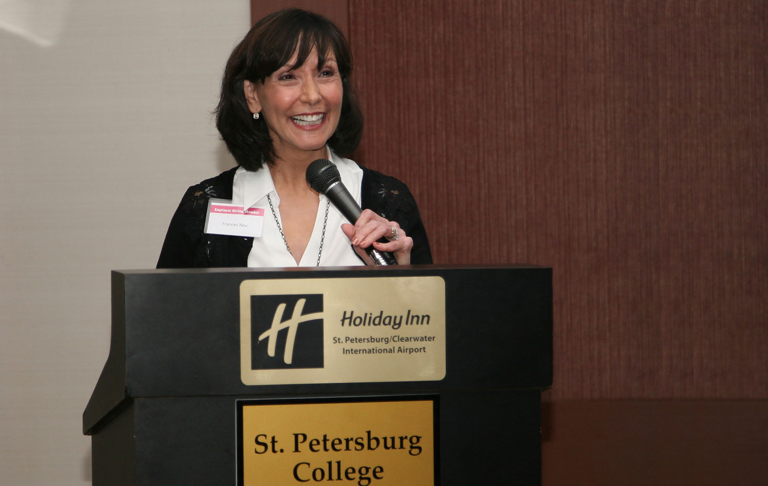 Frances Neu speaking at a podium