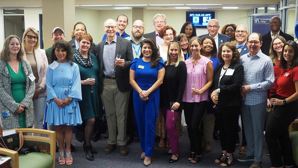 a gathering of attendees facing the camera and smiling