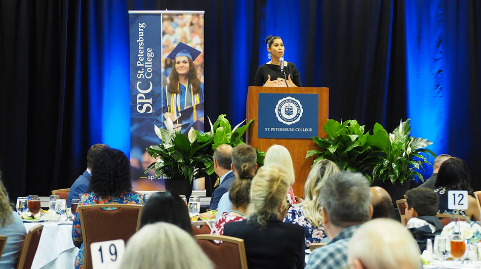 donors and scholars gathered to listen to a speaker at a podium