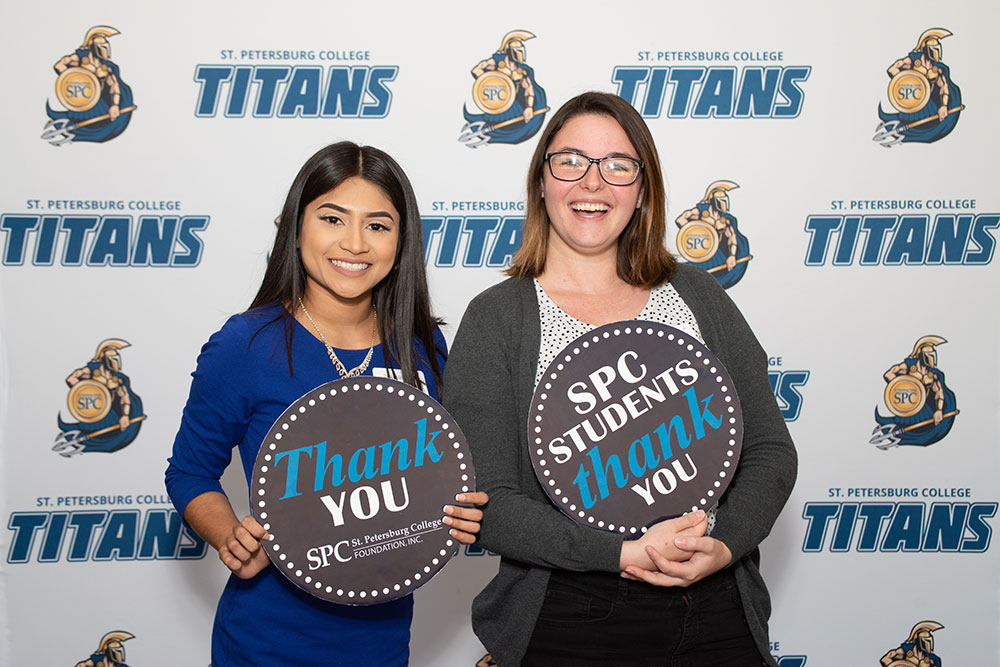 students holding signs that say thank you for the scholarships