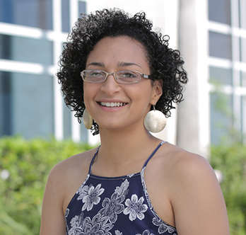 female student wearing a black and white sundress gold earrings