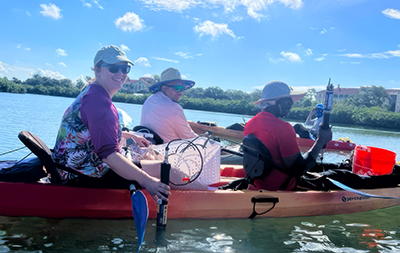 Professor Stephanie Palomino and two students in red and orange kayak