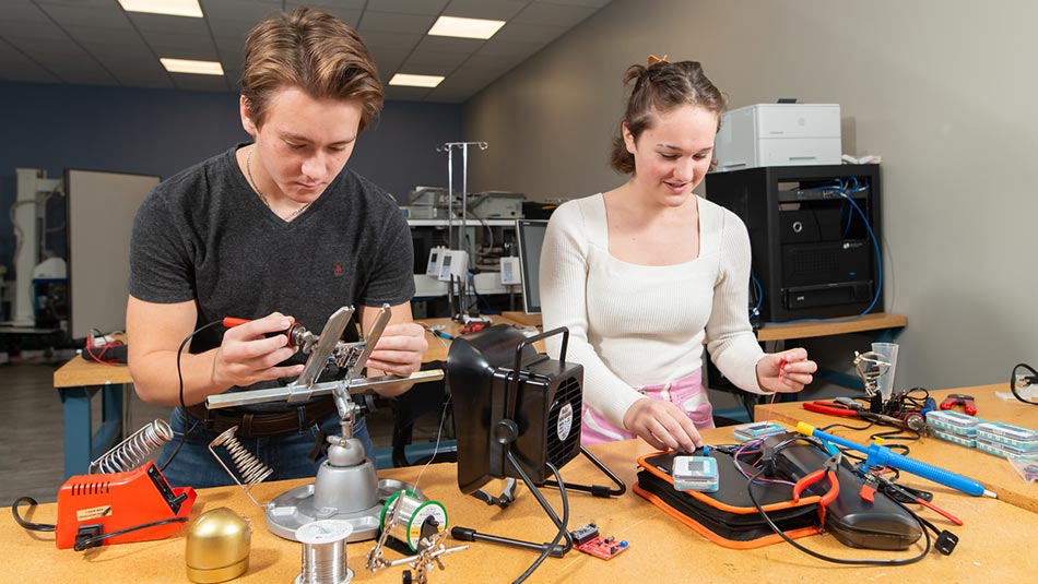 a male and female student working on biomedical equipment