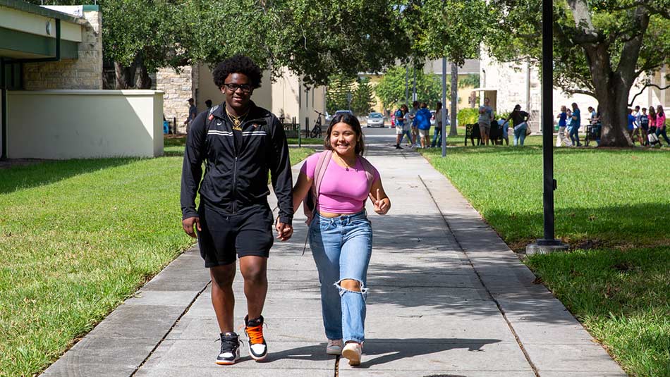 Promise Scholarship student Edith Palma-Hernandez walking on campus holding hands