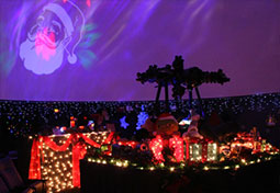 promo image for Yuletide Skies depicting the Planetarium interior decorated for Christmas