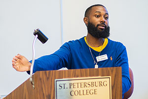 man with blue shirt giving a speech