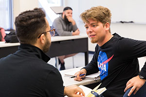 two students talking in classroom