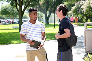 two students standing in capus talking