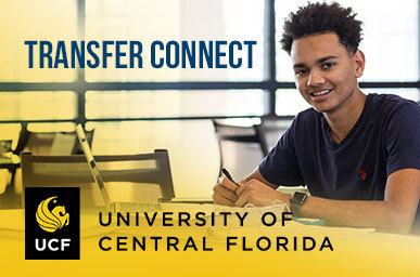 A student, smiling at the camera, sitting at a common area table.