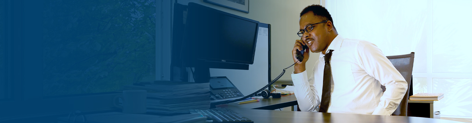 business man seated at a desk speaking on the phone